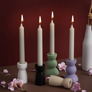 Modern geometric resin candlestick holders in multiple colors with burning white candles