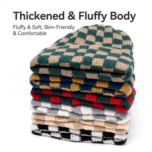 Thick checkerboard knit beanies in various colors stacked on a white background