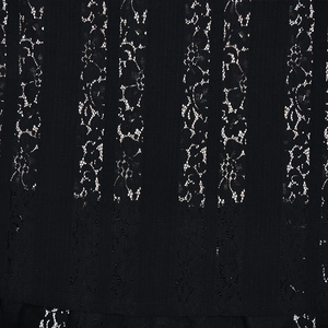 Dettaglio ravvicinato di pizzo floreale nero con fodera beige e strisce verticali