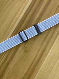 Detailed shot of blue and white striped elastic belt with a black plastic buckle
