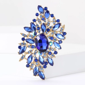 Detailed macro view of vintage gold alloy brooch with deep blue crystals and rhinestones