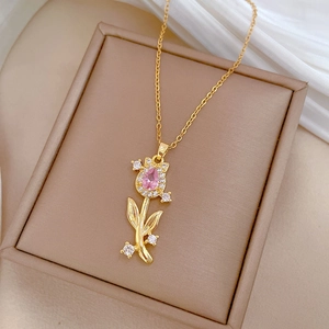 Close-up of golden tulip necklace featuring pink gemstone and sparkling zircons