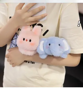 Plush pink rabbit and blue elephant toys worn on wrist with fluffy texture details
