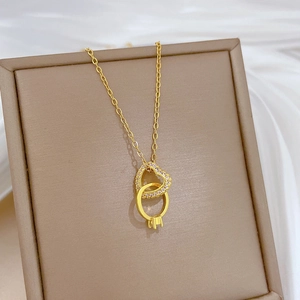 Dettaglio del ciondolo a cuore e anello intrecciati con cristalli su portagioie