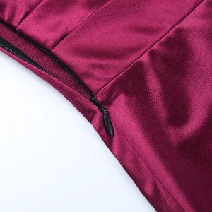 Détail de la fermeture éclair invisible et du tissu magenta sur une robe de soirée
