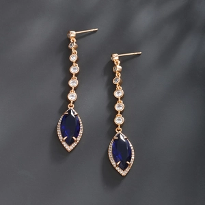 Detail of rose gold dangle earrings featuring navy blue marquise stones and zircon accents