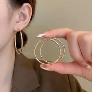 Minimalist large golden hoop earrings for women with high-shine polished metallic finish
