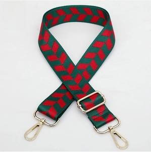 Detail of red and green woven guitar strap with golden metal lobster clasps and buckle