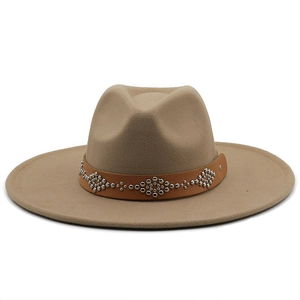 Macro detail of tan felt fedora hat featuring a brown leather band with silver metal studs
