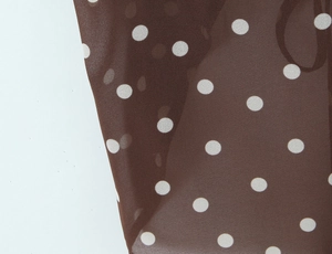 Detailed macro shot of vintage brown and white polka dot chiffon fabric with soft drape