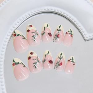 Press-on nail set with pink blush gradient, white French tips, and 3D ladybug art