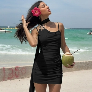 Detail of black ruched mini dress with golden starfish brooch and matching scarf detail