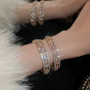 Detail of multi-layer gold bracelet with pink and white sparkling zircon stones