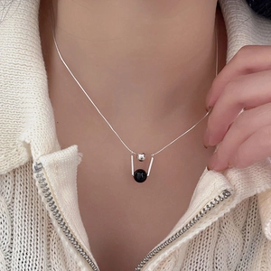 Detail of 925 silver necklace with black onyx bead pendant on minimalist snake chain