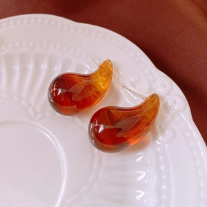Vue macro de boucles d'oreilles en résine ambrée sur une assiette en céramique