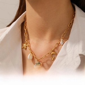 Close-up of beach-style gold necklace with starfish, shell, and dolphin charms on a model