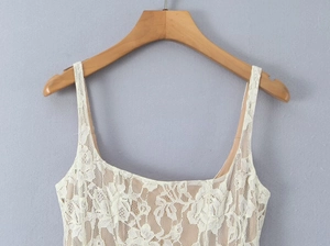Close-up of elegant cream lace tank dress featuring fine floral patterns and thin straps