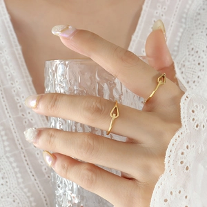 Minimalist 18K gold-plated titanium rings with hollow heart details on a person's hand