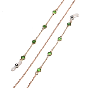 Detail of rose gold glasses chain with green crystal beads and white silicone loops
