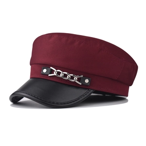 Détail d'une casquette militaire bordeaux avec visière en cuir noir et chaîne argent