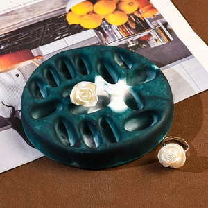 Macro shot of white rose resin rings on a dark green marble textured display tray