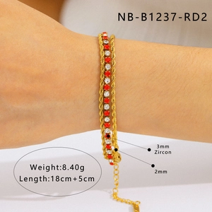Détail du bracelet double couche plaqué or avec zircons rouges et blancs sur le poignet
