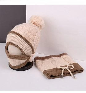 Detail of winter knitted hat and scarf set with fleece lining and faux fur pompom