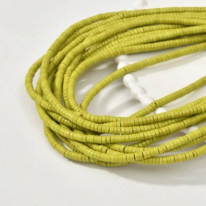 Macro shot of 2x4mm yellow heishi beads for DIY jewelry making and handmade necklaces