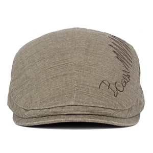 Detail of taupe cotton ivy cap showing textured fabric and cursive embroidery on side