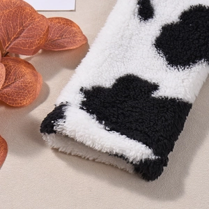 Macro shot showing plush faux shearling texture and black and white cow print on the fabric