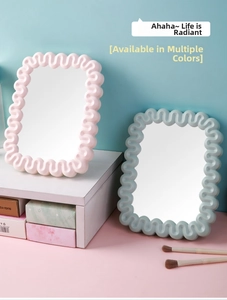 Detail of wavy frame desk mirrors in soft pink and mint blue for vanity makeup