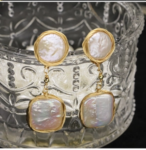 Detailed close-up of handmade baroque pearl drop earrings with gold wire wrapping