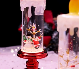 Close-up of a festive Christmas LED candle lantern with snowmen and red metallic base