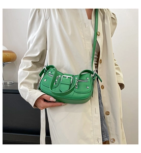 Close-up of vibrant green punk-style crossbody bag with silver studs and buckles