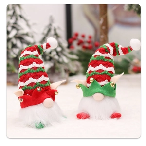 Close-up of plush Christmas forest gnomes with striped knit hats and golden bells