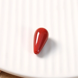 Macro shot of a red vintage teardrop resin bead for DIY jewelry and hair accessories