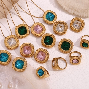 Detailed view of vintage 18K gold plated jewelry with emerald and crystal square stones