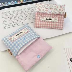 Portable floral cotton sanitary pouch set with snap closure on a laptop background