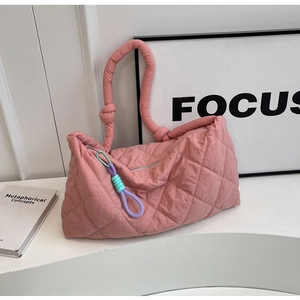 Detail of pink quilted tote bag showing rhombus texture and colorful zipper puller