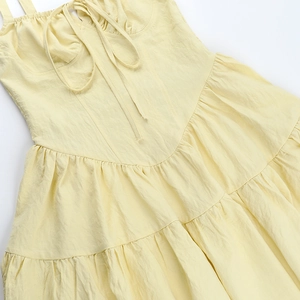 Détail de robe d'été jaune clair avec des plis étagés et un grain de tissu texturé