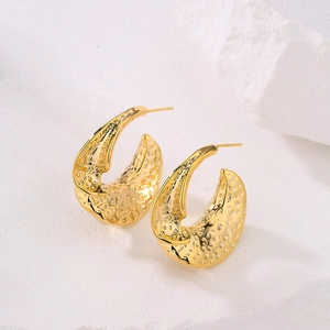 Minimalist 18K gold plated geometric crescent earrings with textured surface on stone background