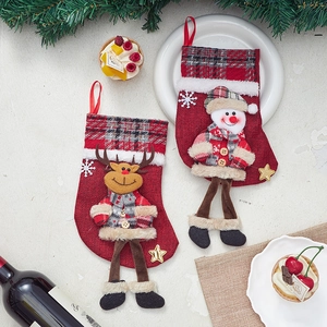 Linen Christmas stockings with 3D snowman and reindeer plush figures on festive tabletop
