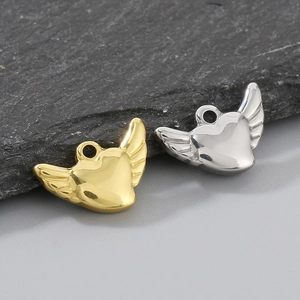 Detailed macro view of gold and silver stainless steel heart pendants with angel wings
