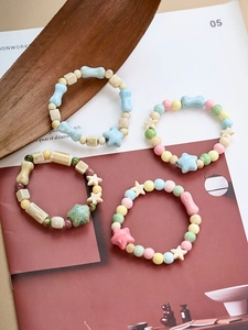 Macro shot of colorful ceramic pastel beads bracelets in star and round shapes