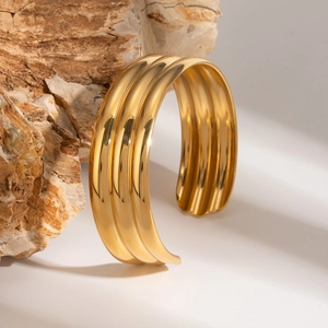 Retro 18k gold plated stainless steel triple-layer open cuff bracelet on a natural rock