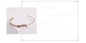 Macro detail of rose gold 316L stainless steel woven knot bangle with adjustable open band