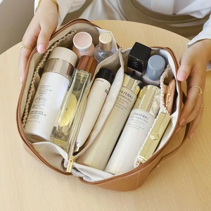 Vue intérieure de la trousse de maquillage en cuir brun avec compartiments élastiques