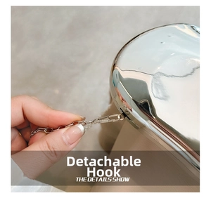 Macro detail of the detachable hook and metallic chain on the silver acrylic clutch bag