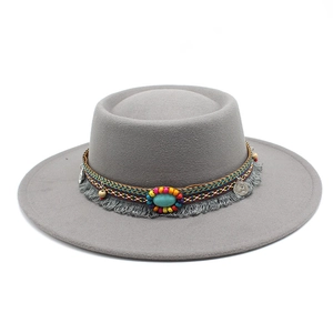 Détail d'un chapeau en feutre gris avec bande bohème en perles et pièces vintage