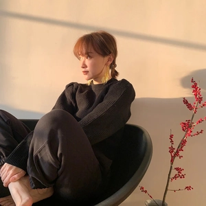 Eleganti orecchini a spillo in oro indossati da una modella in un interno chic